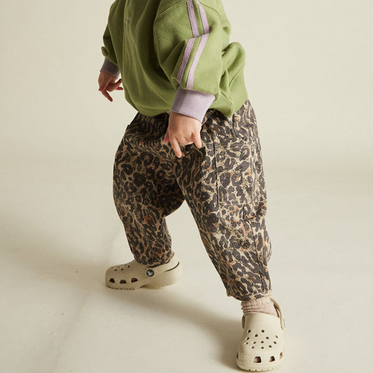 Chic and comfortable kids' pants with a bold leopard print, elastic waistband, cargo pocket details, and relaxed fit.