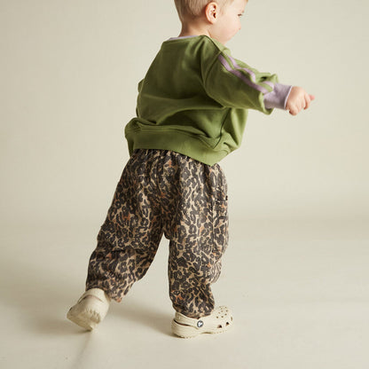 Chic and comfortable kids' pants with a bold leopard print, elastic waistband, cargo pocket details, and relaxed fit.