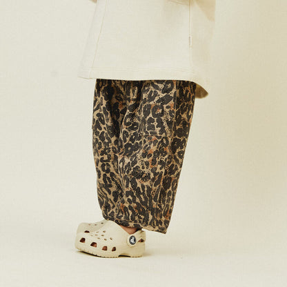 Chic and comfortable kids' pants with a bold leopard print, elastic waistband, cargo pocket details, and relaxed fit.