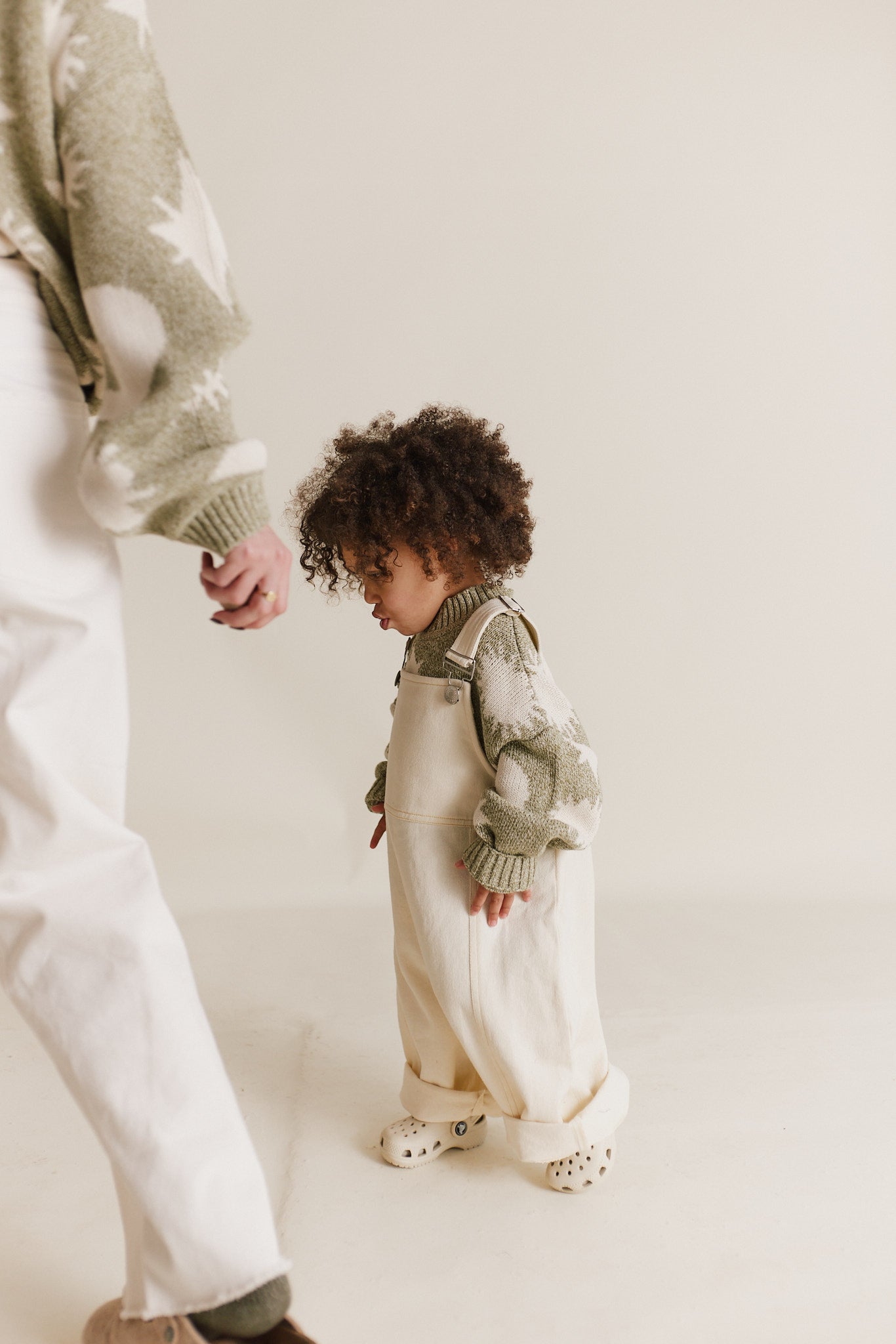 Stylish and comfortable kids' overalls in a cream color featuring a relaxed fit, adjustable straps, and durable organic cotton twill fabric. 