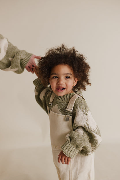 Stylish and comfortable kids' overalls in a cream color featuring a relaxed fit, adjustable straps, and durable organic cotton twill fabric. 